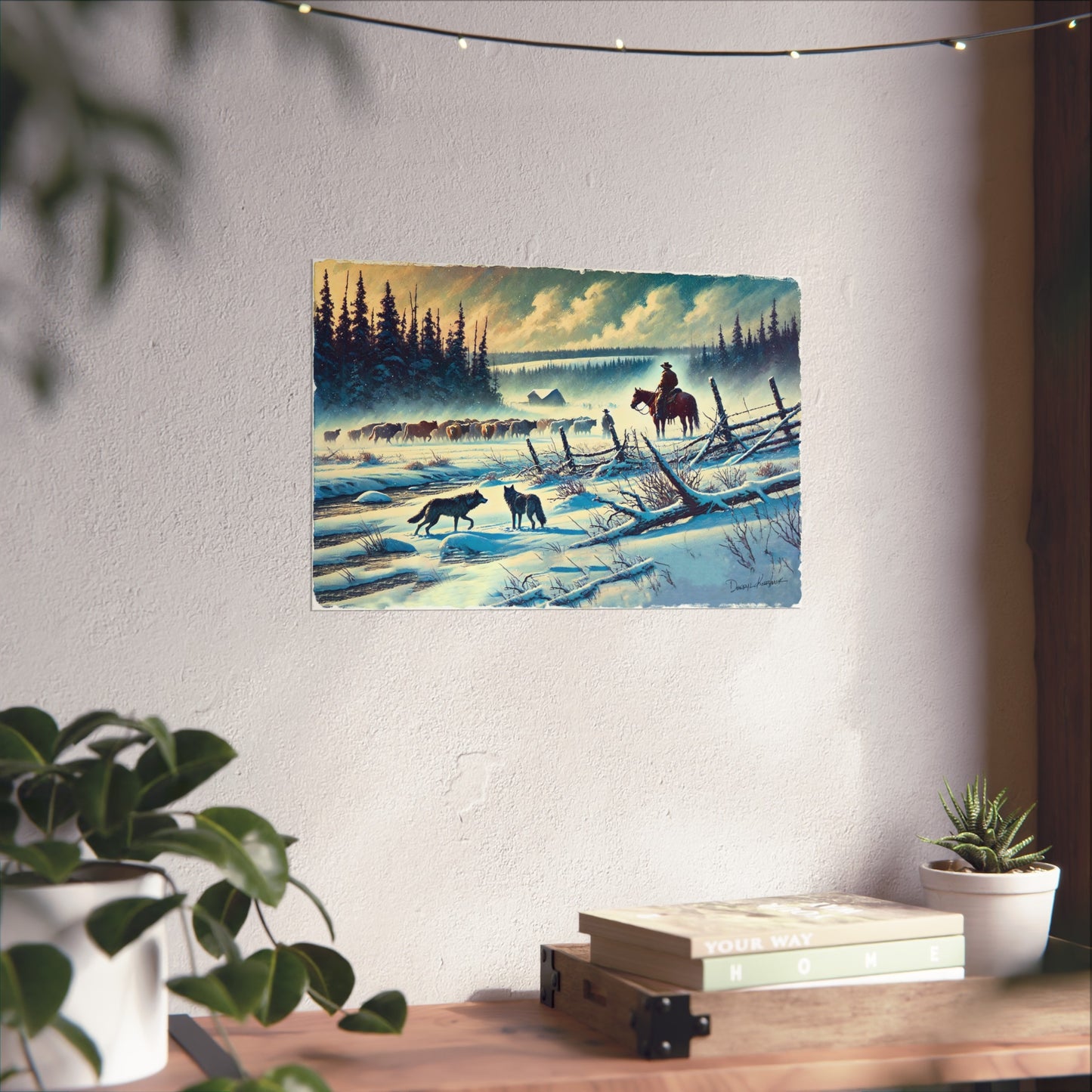 Winter landscape painting with a cowboy on horseback and two wolves, hanging on a wall above a desk.