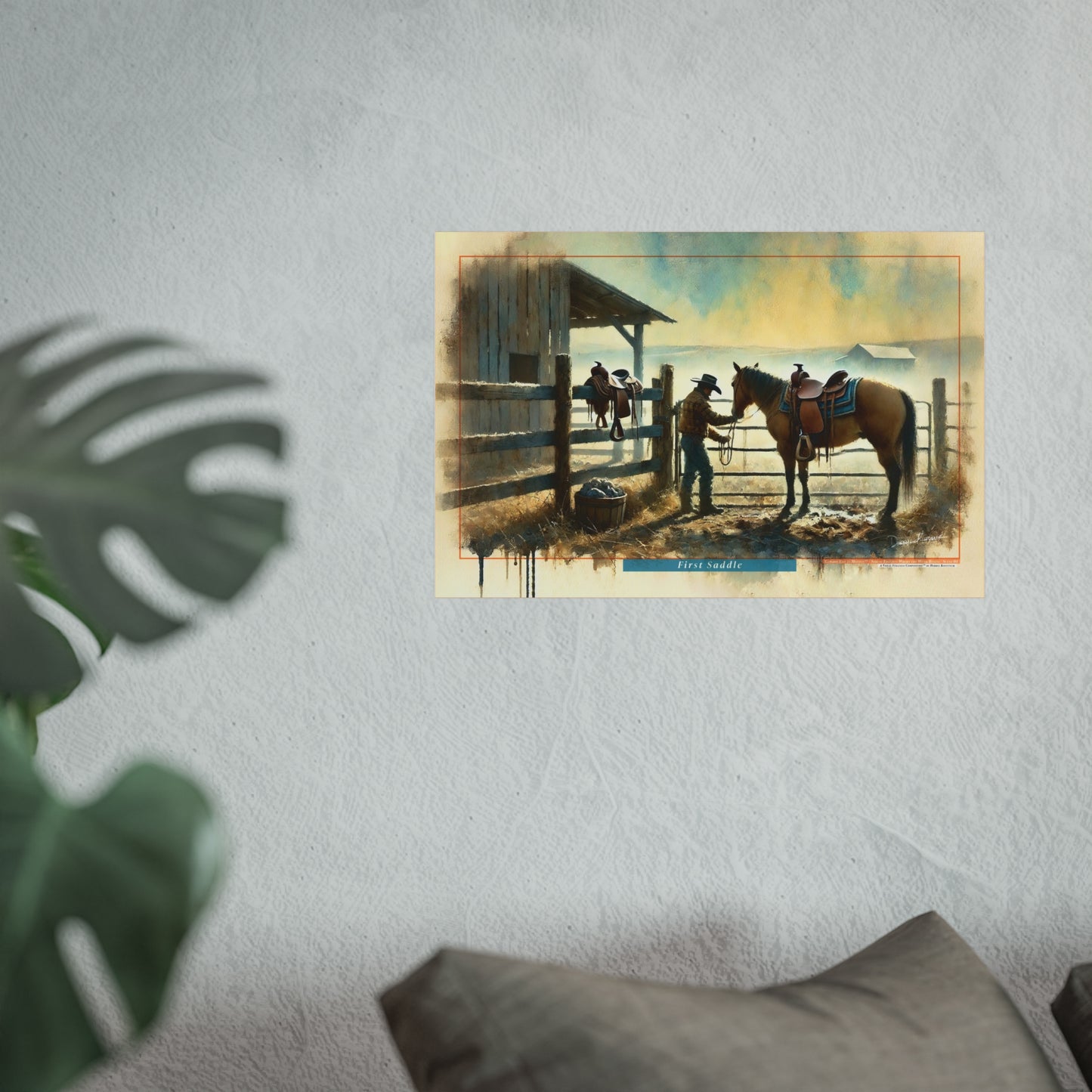 Framed artwork of a cowboy scene on a wall with a plant and pillow in the foreground.