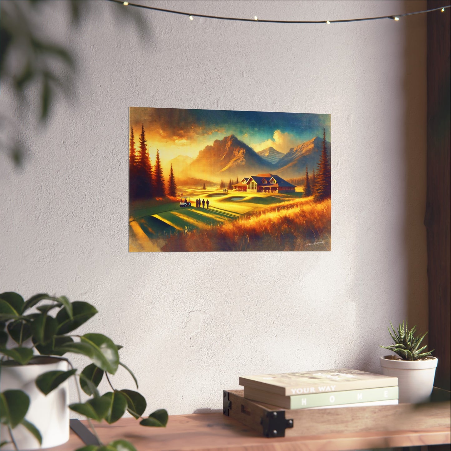 Painting of a mountain landscape with a cabin on a wall above a desk with plants.