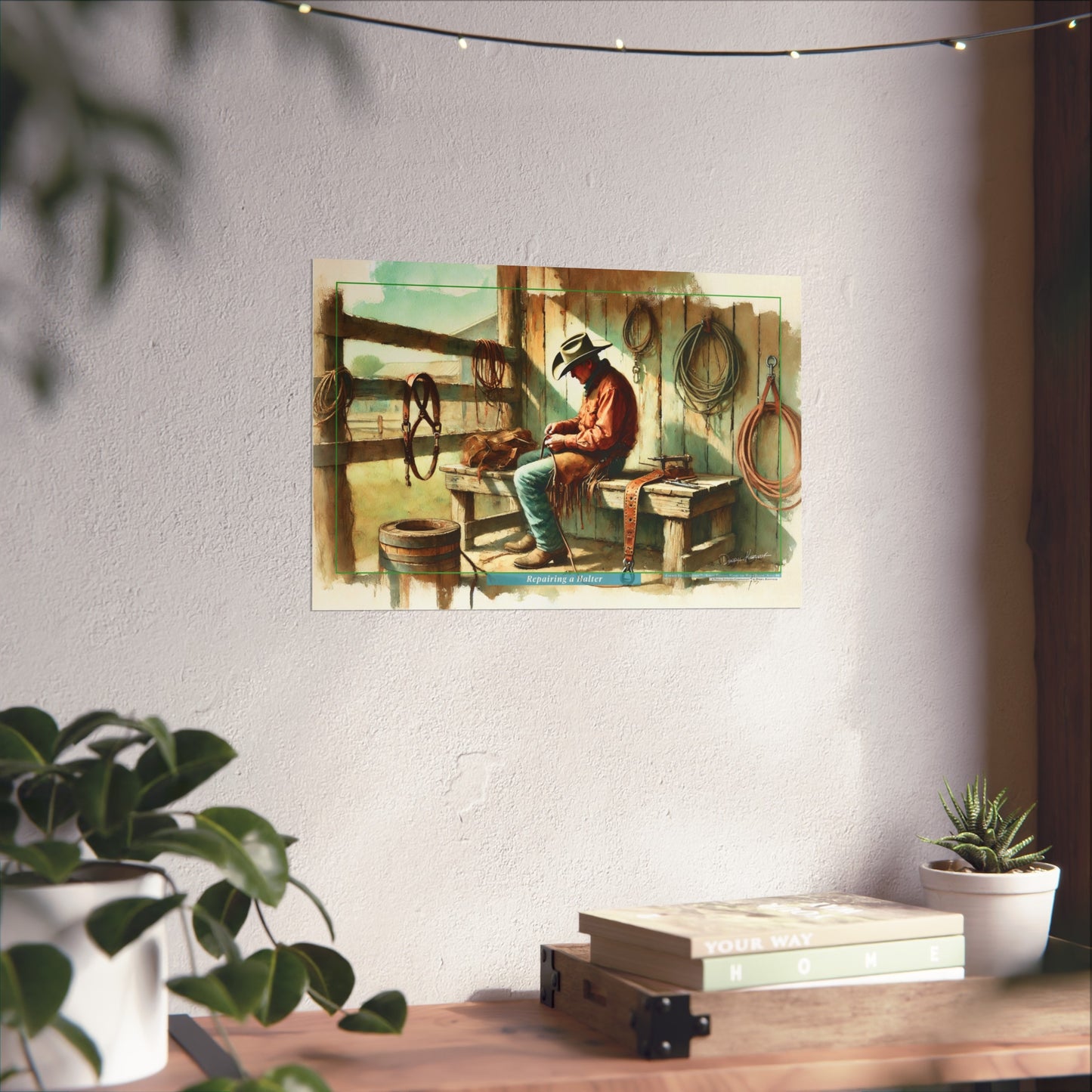 Poster of a cowboy sitting on a bench in a rustic setting on a wall above a desk with plants.