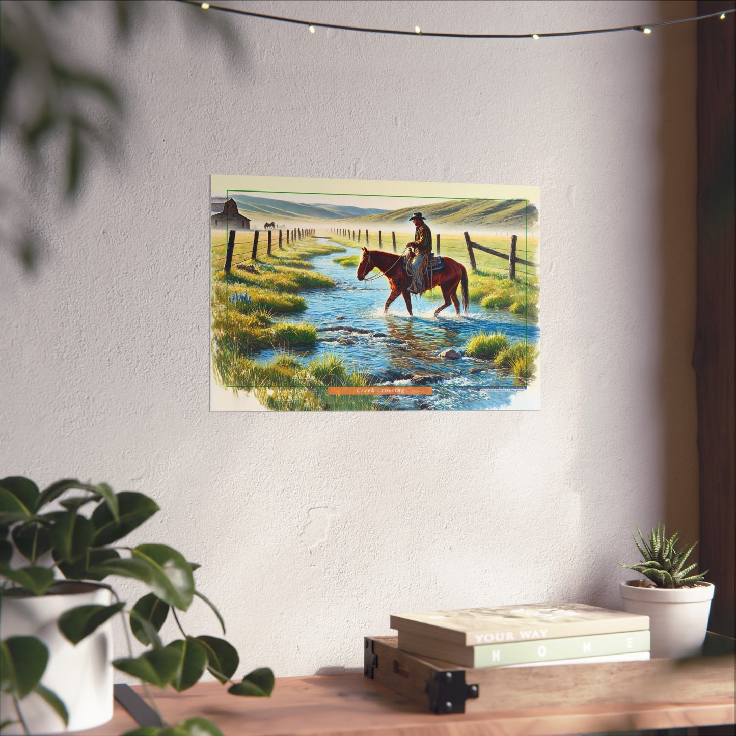 Painting of a cowboy on horseback crossing a stream in a scenic setting, displayed on a wall.
