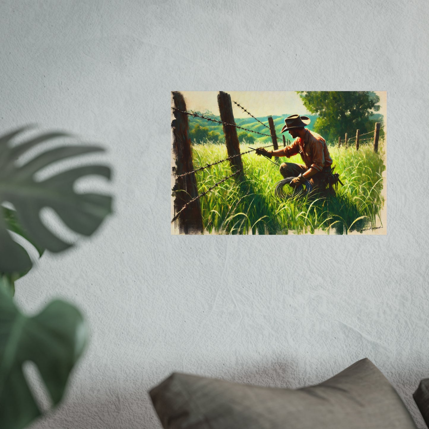 cowboy working on a fence in a grassy field with a scenic background
