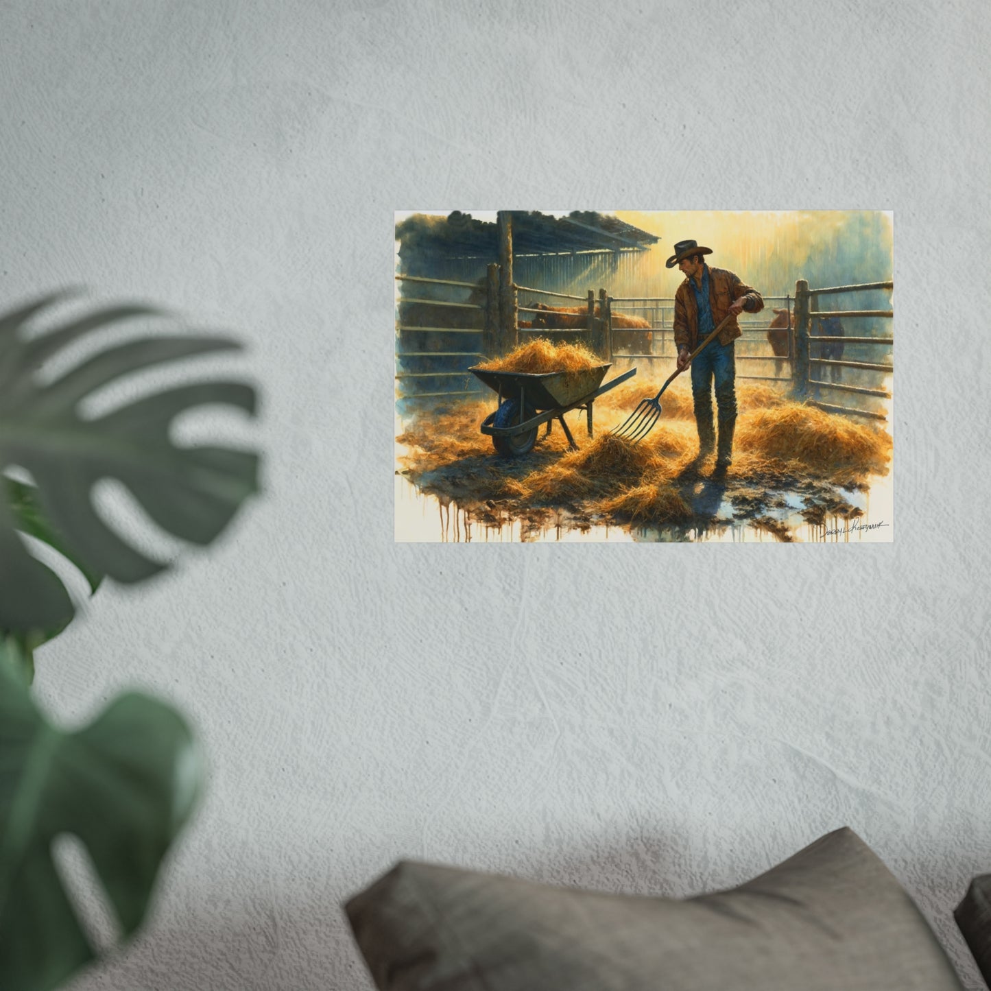 Framed artwork of a cowboy
with a wheelbarrow and pitchfork in a barn setting, displayed on a wall.