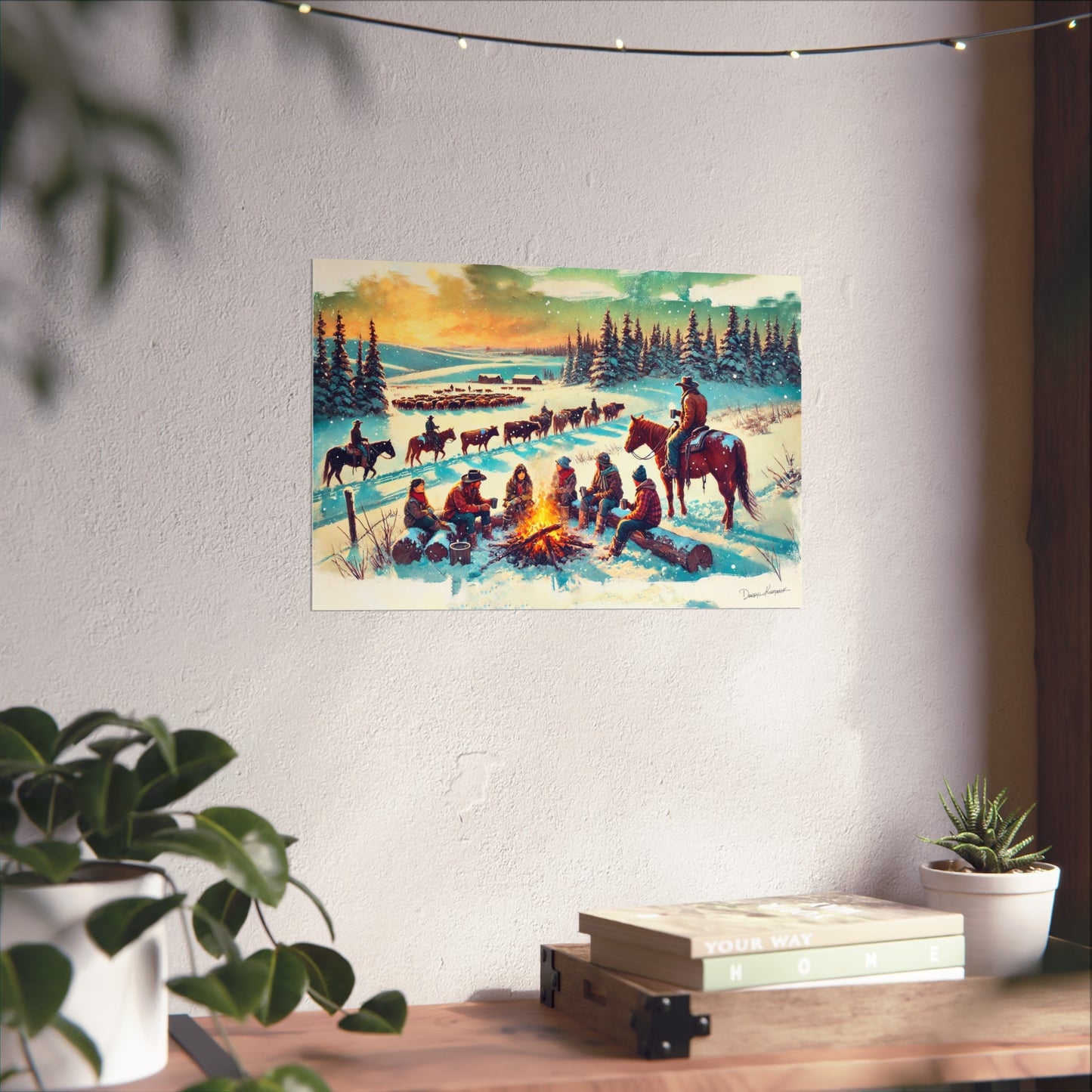 Poster of cowboys around a campfire with horses in a snowy landscape, hanging on a wall.