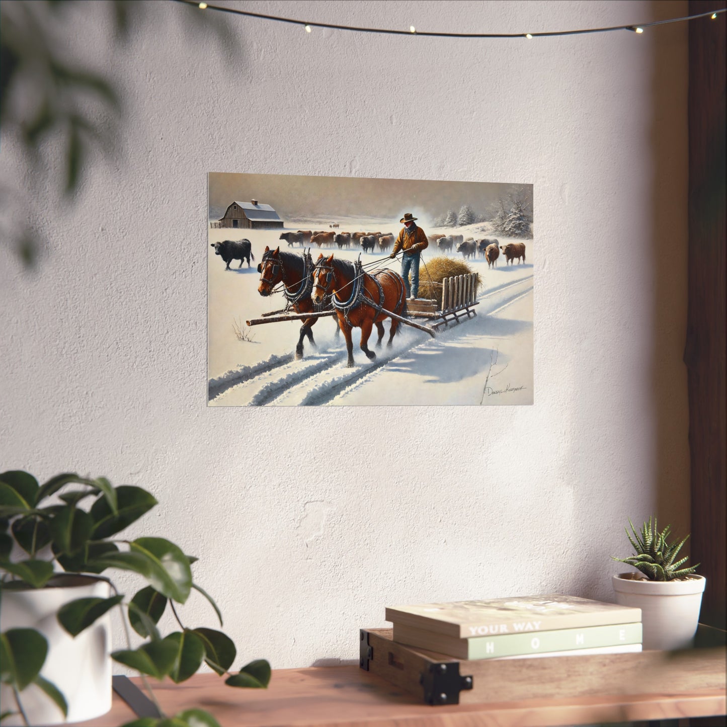 Painting of a Cowboy with horses and a cart on a snowy landscape, displayed on a wall above a wooden desk.