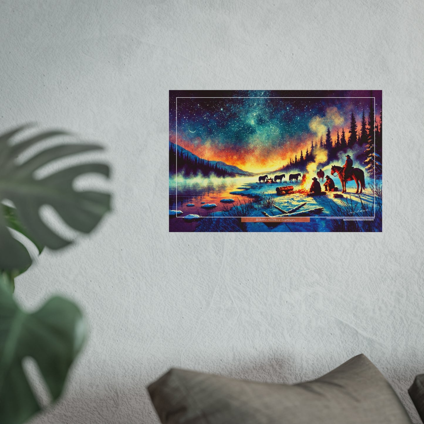Framed artwork of a snowy landscape with cowboys and horses against a starry night sky, on a white wall.