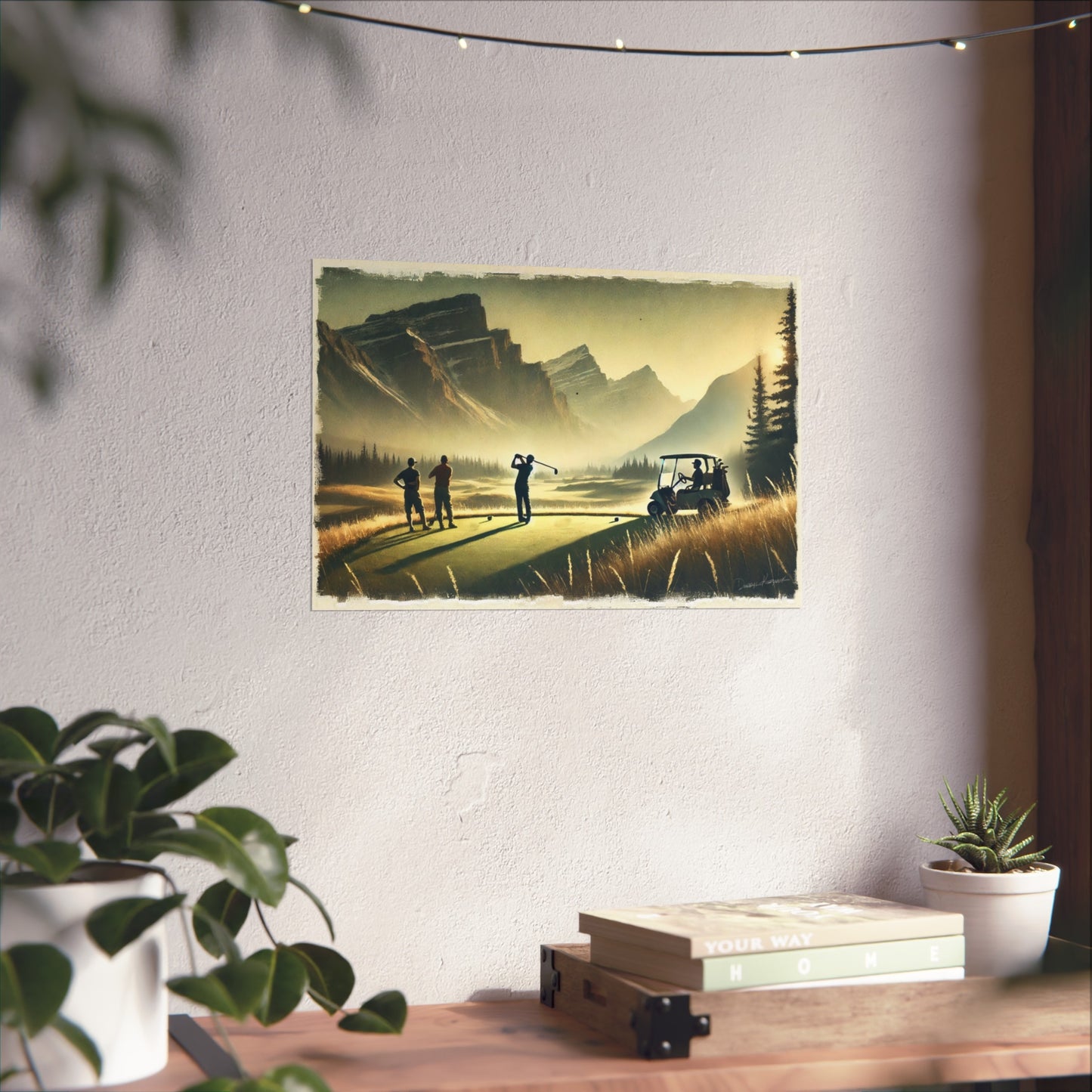 Fine art print of a golf scene on a wall above a desk with plants and books.