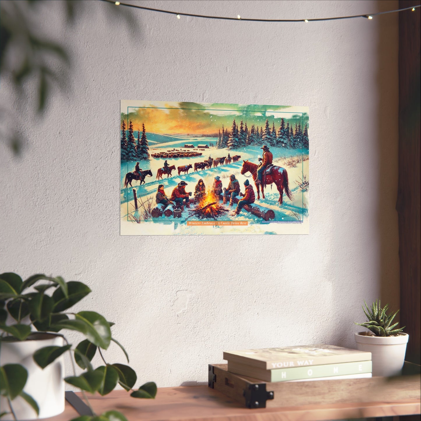 Poster of a snowy landscape with cowboys around a campfire and horses on a wall in a room with plants and books.