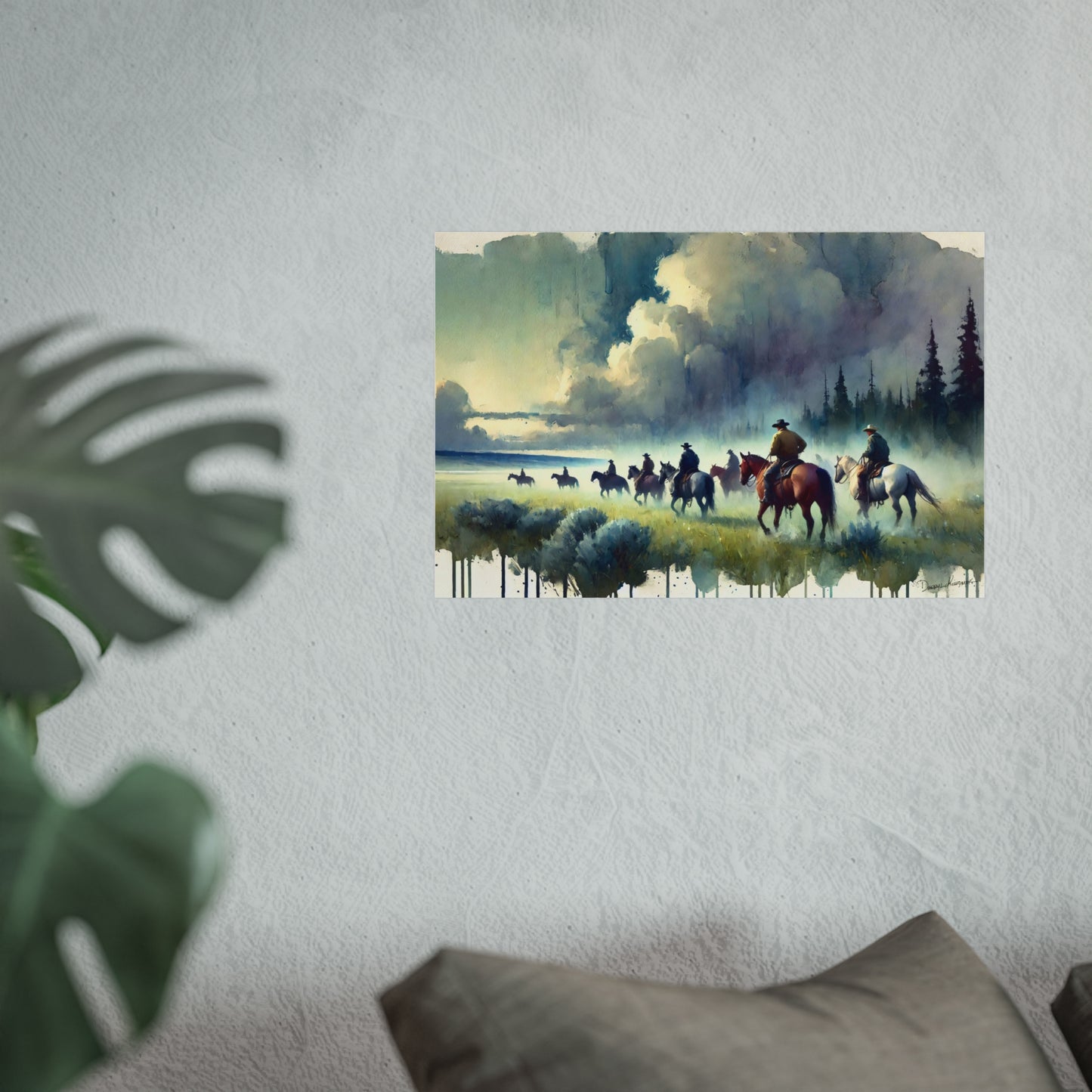 Painting of cowboys on horses near a lake with mountains in the background, displayed on a wall.