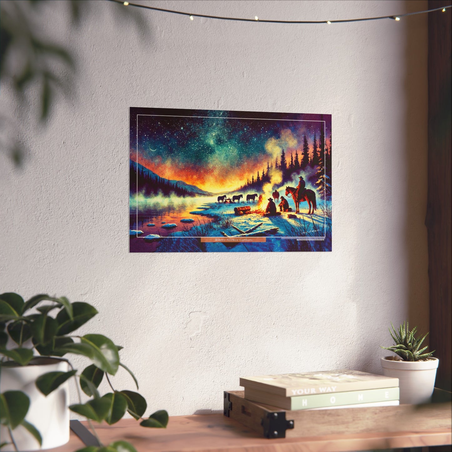 Colorful landscape painting of a campsite with cowboys and horses on a wall above a desk.