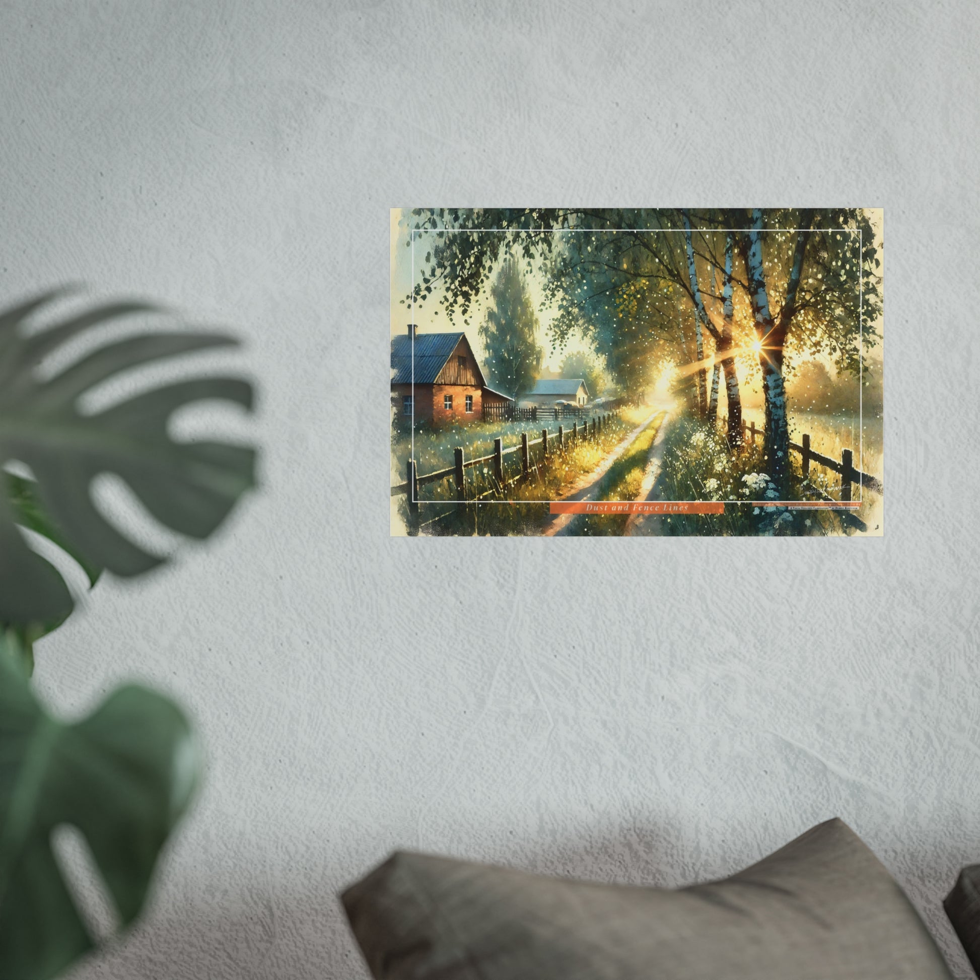 Poster of a scenic landscape with a house and trees on a wall, with a plant and pillow in the foreground.