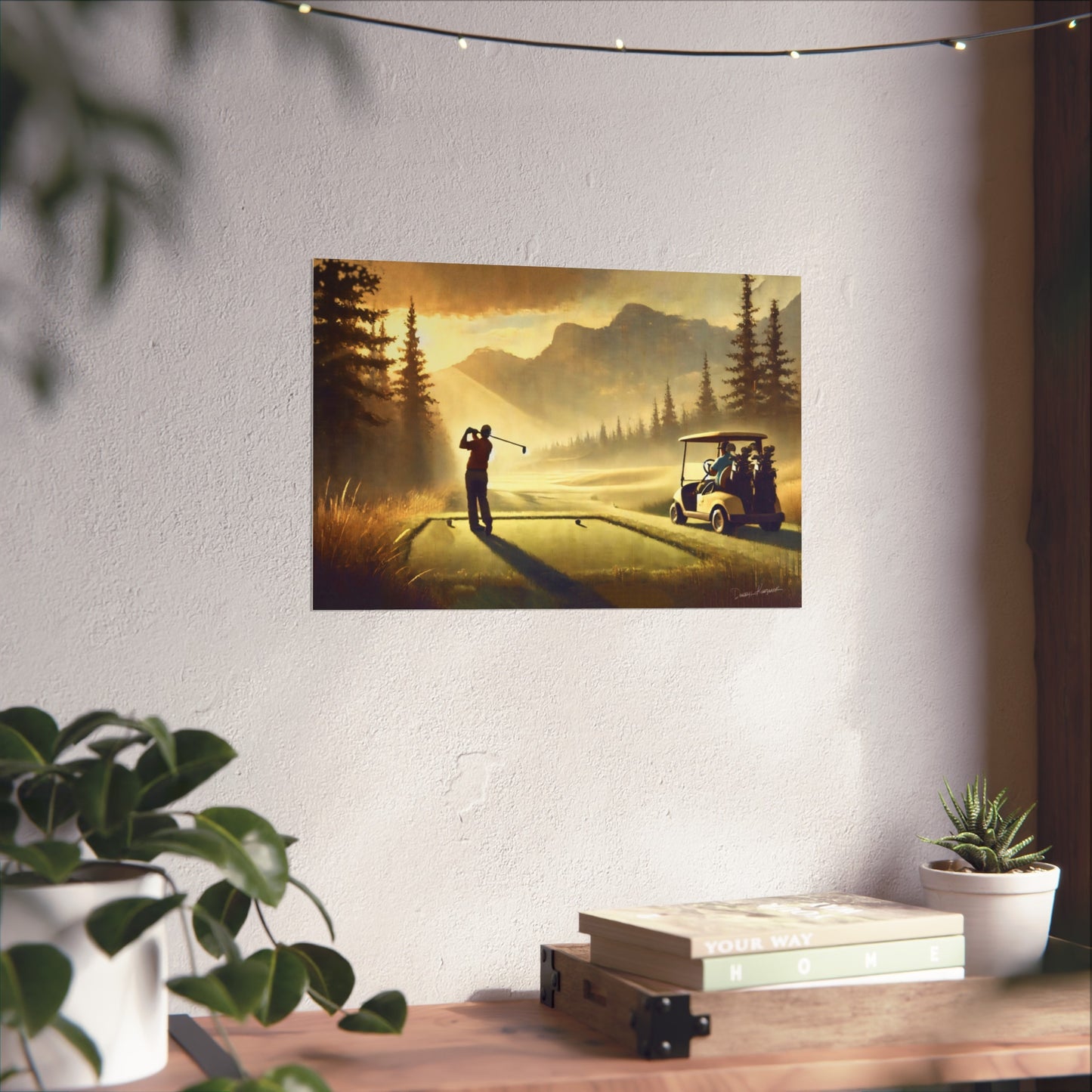 Giclee print of a golf scene on a wall above a desk with plants and books.